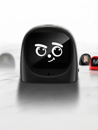 Close-up of a black AI companion robot showing a winking emotional expression screen display on a marble surface.