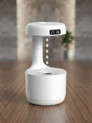 White aesthetic desktop air showing anti-gravity cool mist humidifier water droplet effect and LED clock on a wooden desk.
