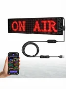 Smartphone controlling a red ON AIR Bluetooth app control LED advertising board via USB cable.
