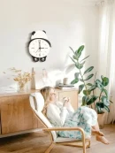 Modern room aesthetic decor clock with panda design mounted in a cozy living room lounge setting.