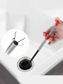 Red press-handle drain cleaning spring wire inserted into a sink to clear blockage easily.